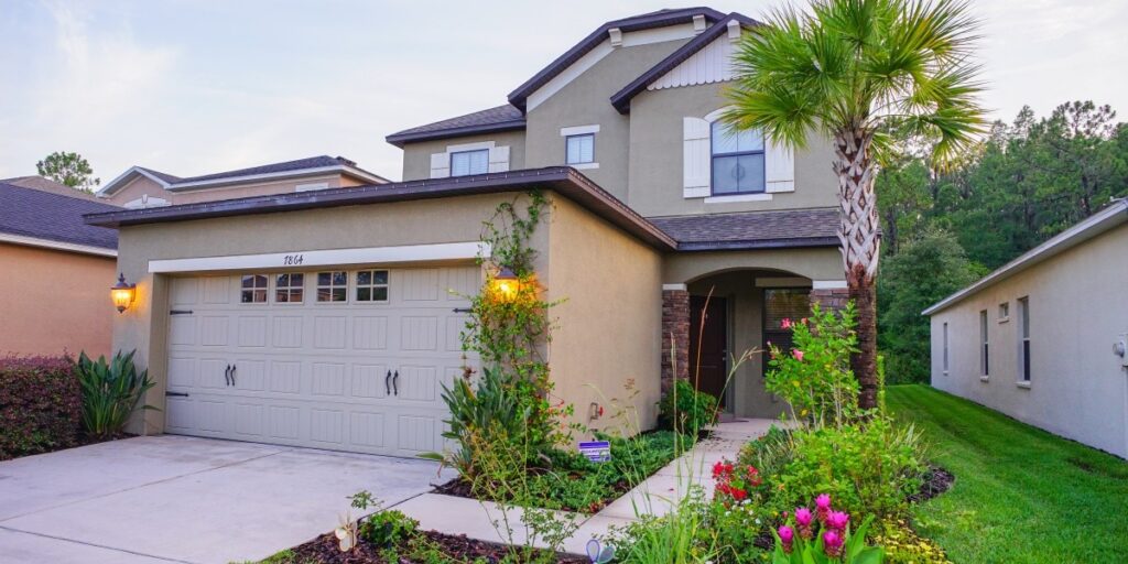 An image of a flower lined walkway wrapping around an extended garage.