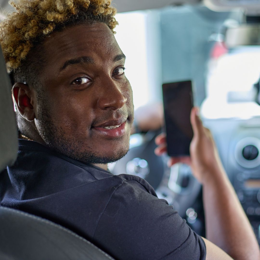 man holding his phone in car